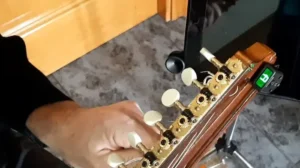 Afinador electrónico mostrando la nota La en una bandurria. Afinando una bandurria con un afinador de cabezal electrónico que muestra la nota A.