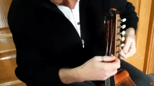 Cambio de cuerdas de bandurria Manos de una persona afinando las clavijas de una bandurria.